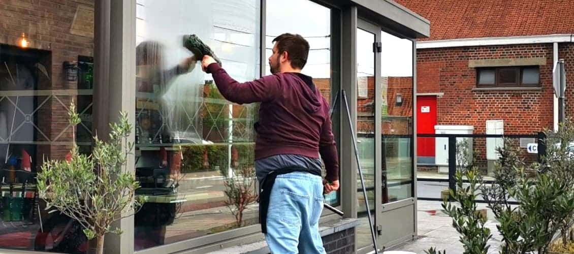 Professionnel USBelgium nettoyant une vitrine à Mouscron